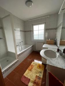 a bathroom with a tub and a sink and a shower at Bungalow in ruhiger Lage in Dietachdorf