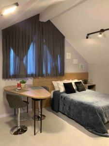 a bedroom with a bed and a table in front of a window at Loft do Vale in Pomerode