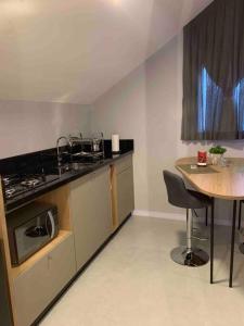 a kitchen with a table and a sink and a counter top at Loft do Vale in Pomerode +7 photos