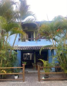 una casa azul con palmeras delante en Lindo Vilage em Praia do Flamengo!, en Salvador