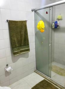 a shower with a glass door in a bathroom at Lindo Vilage em Praia do Flamengo! in Salvador