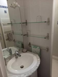 Baño blanco con lavabo y espejo en Agréable maison de village au calme en Sigean