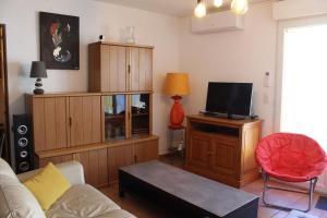ein Wohnzimmer mit einem Sofa und einem Flachbild-TV in der Unterkunft Agréable maison de village au calme in Sigean