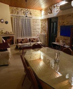 Serenity Stone House, a Blissful Retreat في Petrokefalo: غرفة معيشة مع أريكة وطاولة