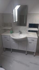 クンプルング・モルドヴェネスクにあるCASA ANA Apartament 2の洗面台と鏡のある白いバスルーム +7枚の写真