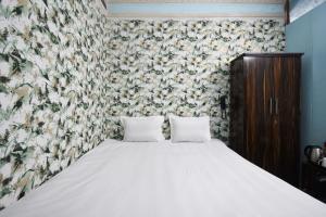 a bedroom with a bed with a floral wallpaper at OYO Blue Cherry Guest House in Ballygunge