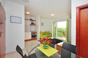 a living room with a vase of flowers on a table at Apartments Beverly in Omiš