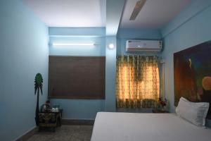 a bedroom with a white bed and a window at OYO Blue Cherry Guest House in Ballygunge