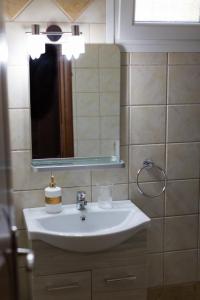 ein Bad mit einem Waschbecken und einem Spiegel in der Unterkunft Irakleitsa Studio in Nea Iraklitsa