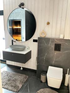 La salle de bains est pourvue d'un lavabo, d'un miroir et de toilettes. dans l'établissement Tondikaku Holiday Home, à Otepää