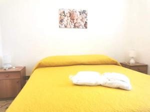 due asciugamani su un letto giallo con due comodini di Villa Giulia ad Alcamo Marina