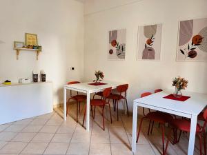 a dining room with two tables and red chairs at The bell tower house in Castrofilippo