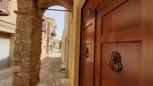 an entrance to a building with a wooden door at Archi di San Giacomo in Cammarata