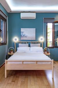 a bedroom with a bed with a blue wall at Panorama Loft in Chalkida