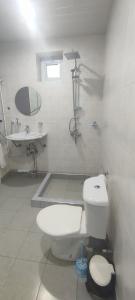 a white bathroom with a toilet and a sink at Continental Hotel Complex in Yerevan