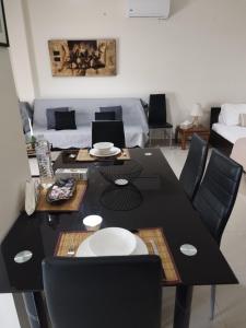 einen schwarzen Esstisch mit schwarzen Stühlen im Wohnzimmer in der Unterkunft Irakleitsa Studio in Nea Iraklitsa