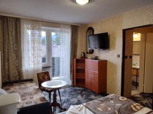 um quarto de hotel com uma cama e uma televisão em Górska Róża em Szklarska Poręba
