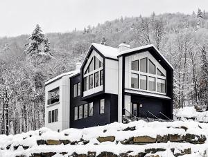una foto en blanco y negro de una casa en la nieve en 32 Chemin Blanc, en Stoneham