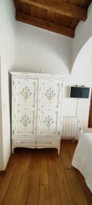 a white dresser in a bedroom with wooden floors at A Casa do Castelo in Estremoz