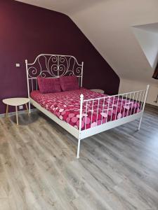 een slaapkamer met een wit bed met roze lakens en een tafel bij Maison d'autrefois in Bouillon