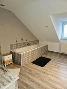 een badkamer op zolder met een bad en een wastafel bij Maison d'autrefois in Bouillon