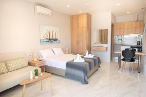 Habitación de hotel con cama y sofá en Beachfront Studio Kyma West ~ Crete's Hidden Gem, en Kalí Limenes
