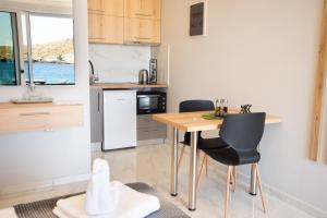 Una cocina con una mesa y sillas en una habitación. en Beachfront Studio Kyma West ~ Crete's Hidden Gem, en Kalí Limenes 3 fotos más