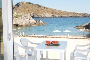 Una mesa y sillas con vista a la playa. en Beachfront Studio Kyma West ~ Crete's Hidden Gem, en Kalí Limenes