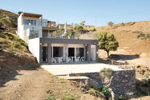 una casa al lado de una colina en Beachfront Studio Kyma West ~ Crete's Hidden Gem, en Kalí Limenes