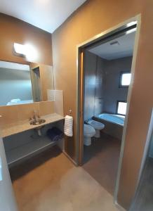 a bathroom with a sink and a toilet and a tub at Acacias Mina Clavero in Mina Clavero