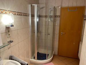 La salle de bains est pourvue d'une douche avec une porte en verre. dans l'établissement City View, à Bodenwerder