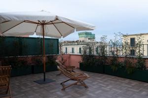 patio z 2 krzesłami i parasolem w obiekcie Le Terrazze sul Vesuvio w mieście Napoli