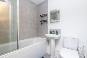 Baño blanco con lavabo y aseo en Wakefield Westgate Station - Central 2 Bed Townhouse - Free Off Road Parking & Fast WiFi, Self Check-in, En-suite Bedrooms, Remote Workspaces & King Size Beds - Suitable for Contractors & Families en Wakefield
