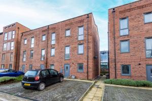a car parked in front of a brick building at Carnforth 91 by Alt-Stay - Wakefield 2 Bed Ensuite Townhouse Contractor and Corporate Accommodation with Private Parking, Smart TV, Kitchen and Fast Wi Fi - Long Stay Ready with Weekly and Monthly Rates in Wakefield +14 photos