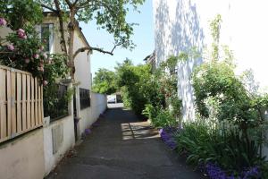 an alley with flowers and plants on the side of a building at Klara's Guesthouse - Chambre chez L'habitant in Bagnolet