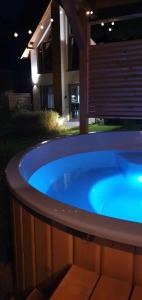 a hot tub in a backyard at night at Sjesta al mare, domki z sauną i balią z jacuzzi in Lubiatowo