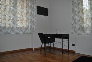 a desk and a chair in a room with curtains at CASA RITA e CASA LUIGI in Turin