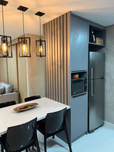 a kitchen with a white table and a refrigerator at Studio a 300m da praia in Maceió +7 photos