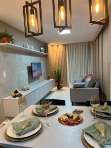 a living room with a table with plates and wine glasses at Studio a 300m da praia in Maceió