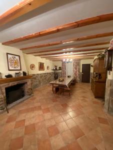 sala de estar amplia con chimenea y mesa en La casa de Serafín y Manoli, en Nestares