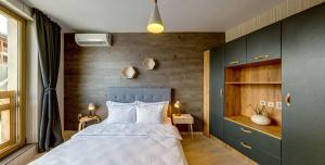 ein Schlafzimmer mit einem Bett und einer Holzwand in der Unterkunft BOUTIQUE Hotel ENTRY E in Bansko