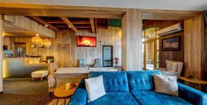 a living room with a blue couch and a kitchen at BOUTIQUE Hotel ENTRY E in Bansko