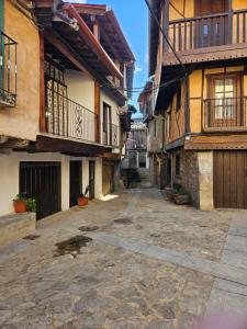 una calle vacía en un viejo pueblo con edificios en Casa Cefita, en Madroñal