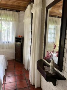 ein Schlafzimmer mit einem Spiegel und einem Bett in einem Zimmer in der Unterkunft Pousada House Sol & Praia in Torres