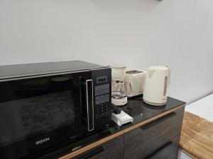 a black microwave oven sitting on top of a counter at غرفة شذا طيبة المخدومة Shaza Taibah Luxury Room in Medina