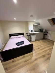 a bedroom with a large bed and a desk at L-Houses in Dagenham