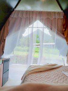a bed in a room with a window at Flora Glamping de Abuela in Fortuna