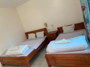 two beds in a room with white sheets at Dao homestay Vũ Linh in Yên Bình