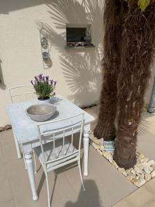 a white table and chair next to a tree at B&B Nathalie in Quartino