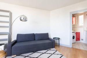 a living room with a blue couch in a white room at Appart Plein Soleil Seine Paris 5ème Jardin Plantes in Paris